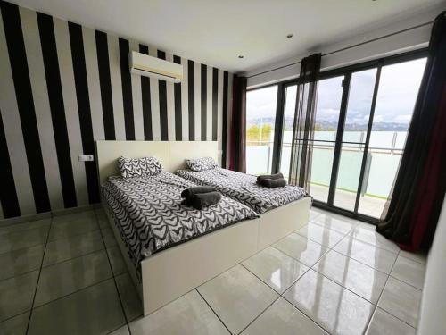 a bedroom with a bed and a large window at Villa Claudie in Les tres Cales