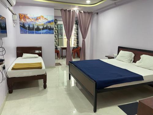 a bedroom with two beds and a living room at BMR BALA LODGE in Nandyāl