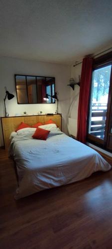 une chambre avec un lit et une grande fenêtre dans l'établissement Résidence le chalet des orres, aux Orres