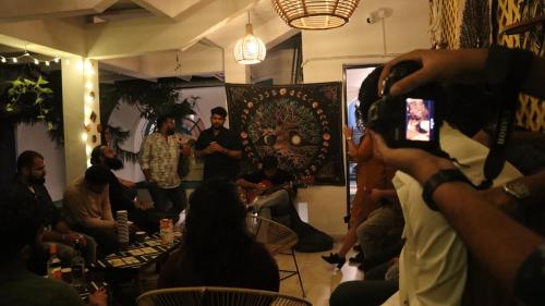 a man taking a picture of a crowd of people in a room at House of Stories - Indiranagar in Bangalore
