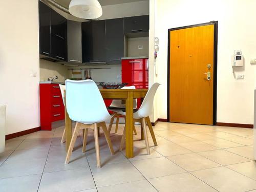 a kitchen with a wooden table and two white chairs at Appartamento Corte Salvemini in Bologna