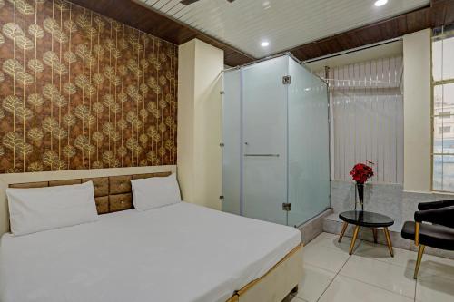 a bedroom with a white bed and a glass shower at Super OYO Hotel Krishna Guest House & PG in Ludhiana