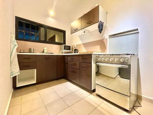 a kitchen with brown cabinets and a stove top oven at Villa SE2 27 in Baguida