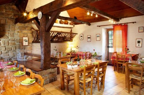 - un restaurant avec des tables et des chaises en bois dans une chambre dans l'établissement Maison charmante à Plouégat-Moysan avec spa, à Plouégat-Moysan