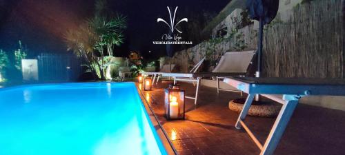 un tavolo da ping pong accanto alla piscina di notte di Villa Kinga ad Anzio