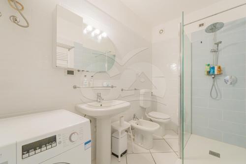 a white bathroom with a sink and a shower at Il Porto 25 Mansarda sul Mare - Goelba in Porto Azzurro