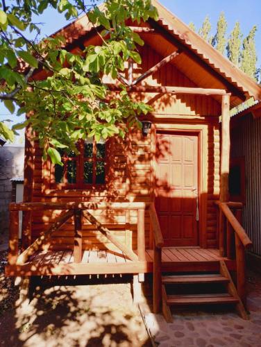 een hut met een veranda en een bank ervoor bij Teushen 5 in Perito Moreno