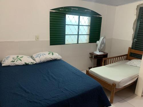 a bedroom with a blue bed and a window at Samambaia 01 in Brasilia