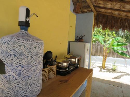 un grand vase assis sur une table dans une cuisine dans l'établissement Pitico Chalé - Icaraí Kite Village, à Icaraí