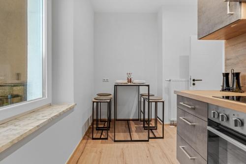a kitchen with a counter and stools in it at Frisch renovierte Wohnung - Zentral/Ruhig/Modern in Augsburg