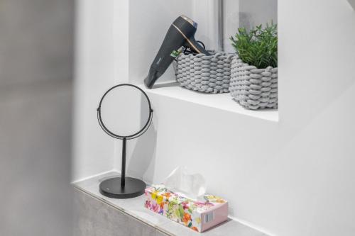 a mirror on a shelf with gifts and plants at Frisch renovierte Wohnung - Zentral/Ruhig/Modern in Augsburg