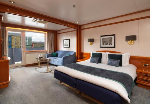1 dormitorio con 1 cama, 1 sofá y 1 silla en Sunborn London Yacht Hotel en Londres