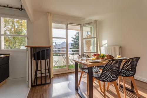 une cuisine avec une table et des chaises et une fenêtre dans l'établissement Place Cosy - Charmant appt pour 4, Évry-Courcouronnes
