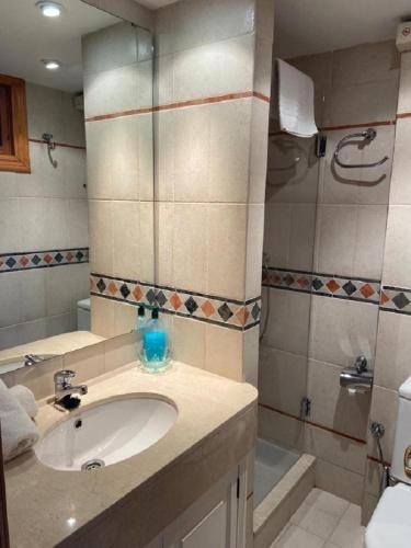 y baño con lavabo, ducha y bañera. en Nievemar Edificio Montebajo, Dúplex en Zona Baja en Sierra Nevada