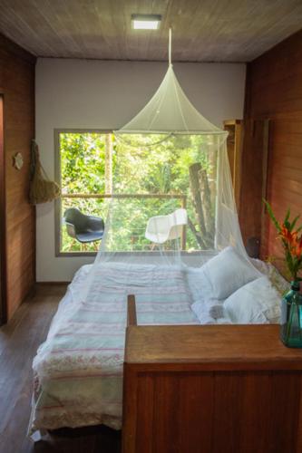a bedroom with a large bed with a canopy at Casa Grande Flats in Abraão
