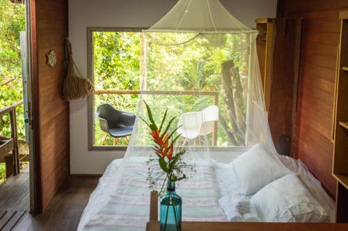 a bed in a room with a large window at Casa Grande Flats in Abraão