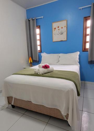 a bedroom with a large bed with a blue wall at CASA CAMINHO do MAR in Pôrto de Pedras