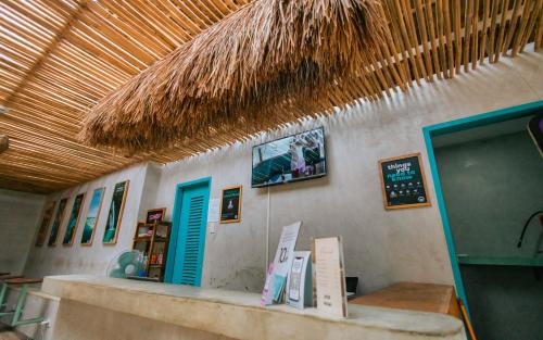 愛妮島的住宿－Mad Monkey Hostel Nacpan Beach，一间墙上有柜台和标志的餐厅