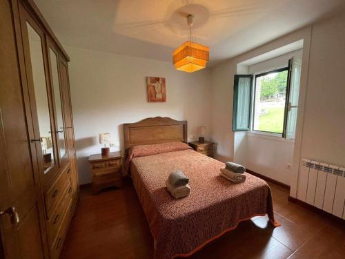 ein Schlafzimmer mit einem Bett mit zwei Hüten darauf in der Unterkunft Grupo Gontad Casa Balsas in A Coruña