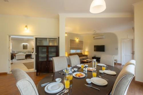 a dining room with a table and chairs at Hostie Humming Trees - 4BHK Farm house, Opp Westin Sohna in Sohna