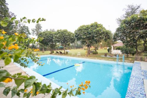 a swimming pool with a boat in a yard at Hostie Humming Trees - 4BHK Farm house, Opp Westin Sohna in Sohna