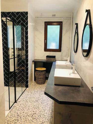 une salle de bain avec un lavabo et un miroir dans l'établissement Maison au calme proche ville, à Nîmes