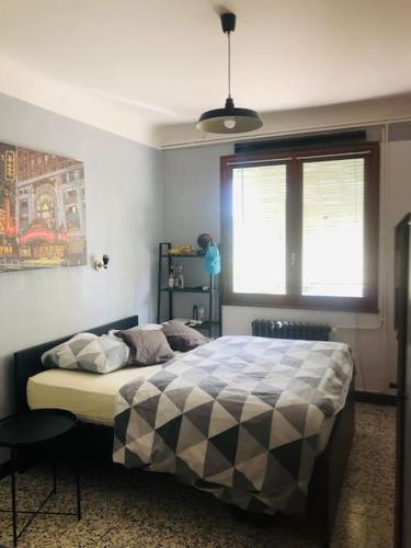 une chambre avec un lit avec une couverture à carreaux dans l'établissement Maison au calme proche ville, à Nîmes