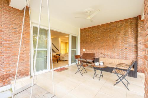 a living room with a brick wall at Hostie Humming Trees - 4BHK Farm house, Opp Westin Sohna in Sohna