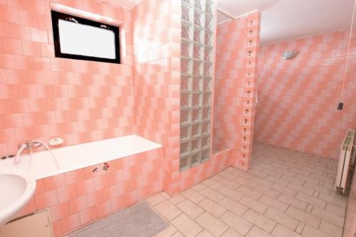 a pink bathroom with a sink and a shower at Jestřebí chalupa in Rtyně v Podkrkonoší