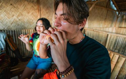 a man and a girl eating food in a booth at Mad Monkey Hostel Nacpan Beach in El Nido