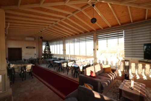 sala de estar con sofá, mesas y sillas en Hotel İzi Cappadocia, en Ürgüp