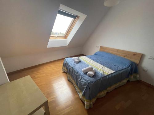 a small bedroom with a bed and a window at Grupo Gontad Ático Neaño in A Coruña