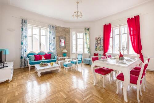 ein Wohnzimmer mit roten Vorhängen sowie einem Tisch und Stühlen in der Unterkunft Amazing View Designer Home with Sauna and Jacuzzi 3 min to Opera House in Budapest