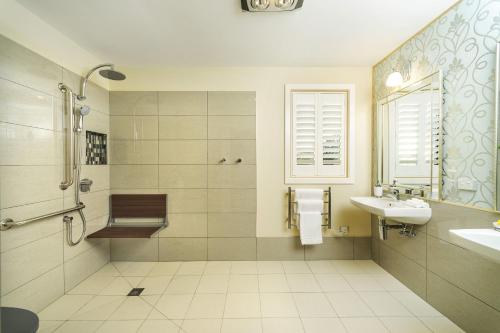 a white bathroom with a sink and a shower at Coastal Pods Wynyard in Wynyard