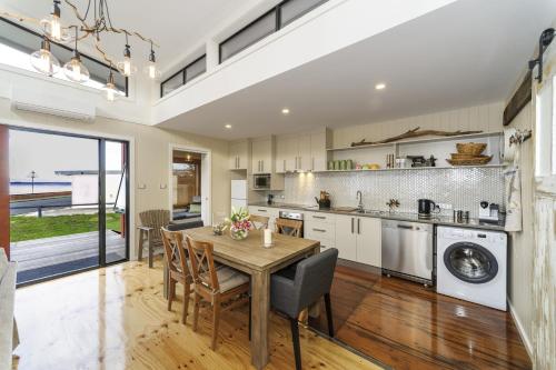 a kitchen and dining room with a table and chairs at Coastal Pods Wynyard in Wynyard