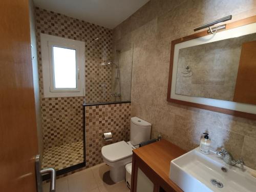 a bathroom with a toilet and a sink and a shower at VILLA REPOSO in Calafat