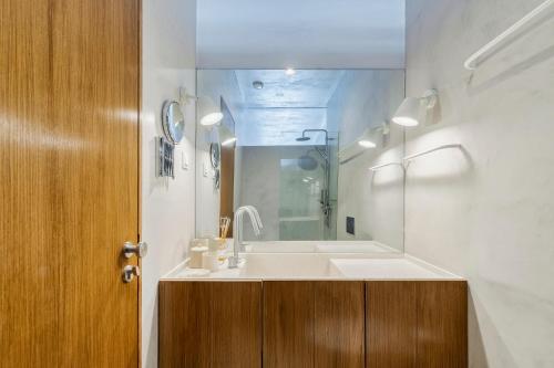 een badkamer met een wastafel en een spiegel bij Azul by the Sea in Setúbal