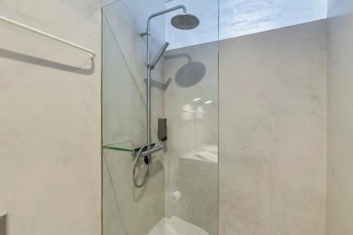 een douche met een glazen deur in de badkamer bij Azul by the Sea in Setúbal