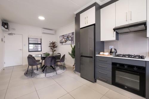 a kitchen with a table and a dining room at Ballito Village Luxury Apartments in Ballito