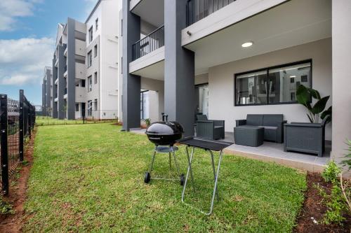 a grill sitting on the grass outside of a building at Ballito Village Luxury Apartments in Ballito