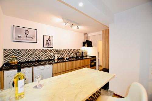 a kitchen with a table with a bottle of wine at Apartamento Aperitivo in Tavira