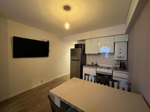 a kitchen with a table and a refrigerator and a stove at DADELF in Rosario