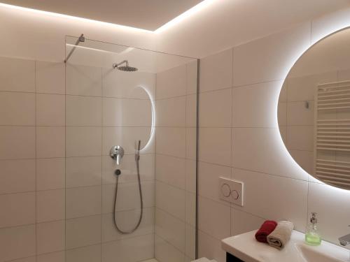 uma casa de banho com um chuveiro e um lavatório. em Hager Apartment em Merano