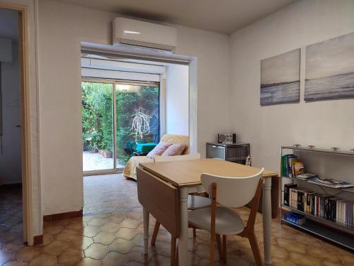 une salle à manger avec une table, des chaises et un canapé dans l'établissement Petit paradis avec jardin et clim T2, à Saint-Mandrier-sur-Mer