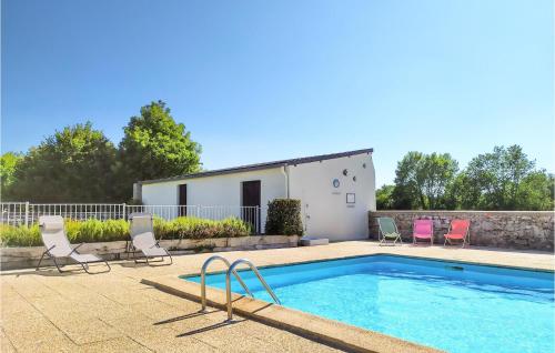 a swimming pool with chairs and a house at Beautiful Home In Montmartin-Sur-Mer in Montmartin-sur-Mer