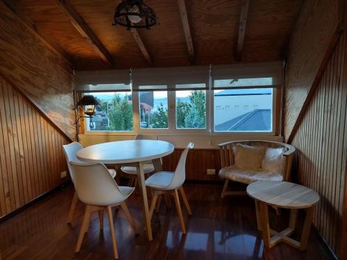 uma sala de jantar com uma mesa e cadeiras e uma janela em Departamento completo en San Carlos de Bariloche, Argentina em San Carlos de Bariloche
