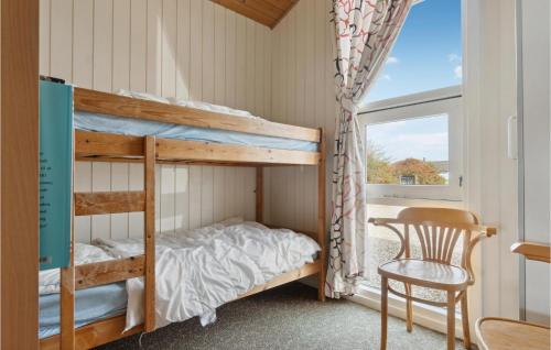 a bunk bed in a room with a chair and a window at Gorgeous Home In Vestervig With Indoor Swimming Pool in Vestervig