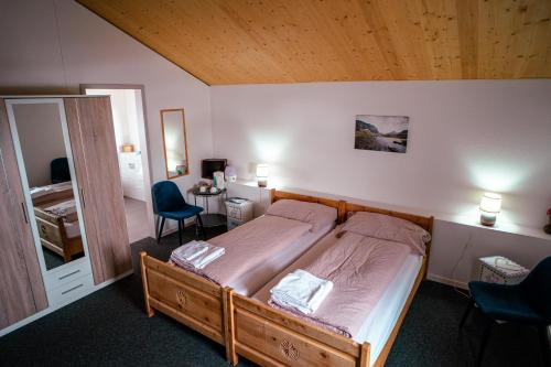 a bedroom with a bed and two chairs and a mirror at Ospizio La Veduta in Bivio