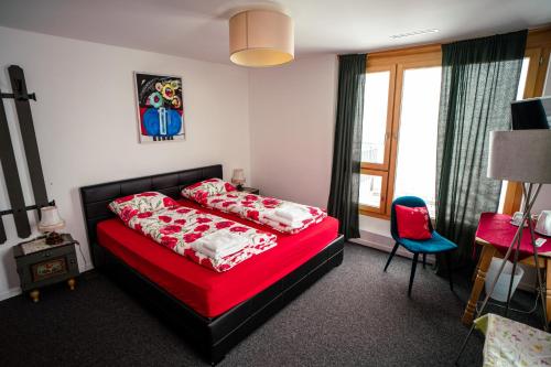 a bedroom with a red bed and a red chair at Ospizio La Veduta in Bivio