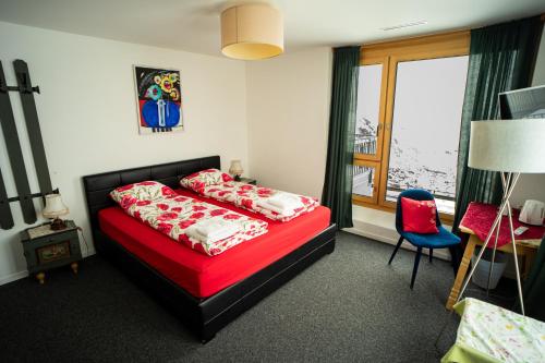 a bedroom with a red bed and a red chair at Ospizio La Veduta in Bivio
